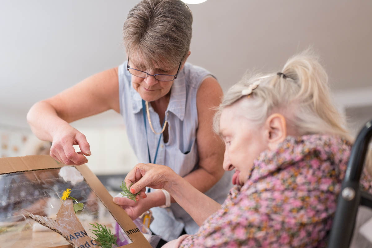 Staff member assisting resident with an activity.