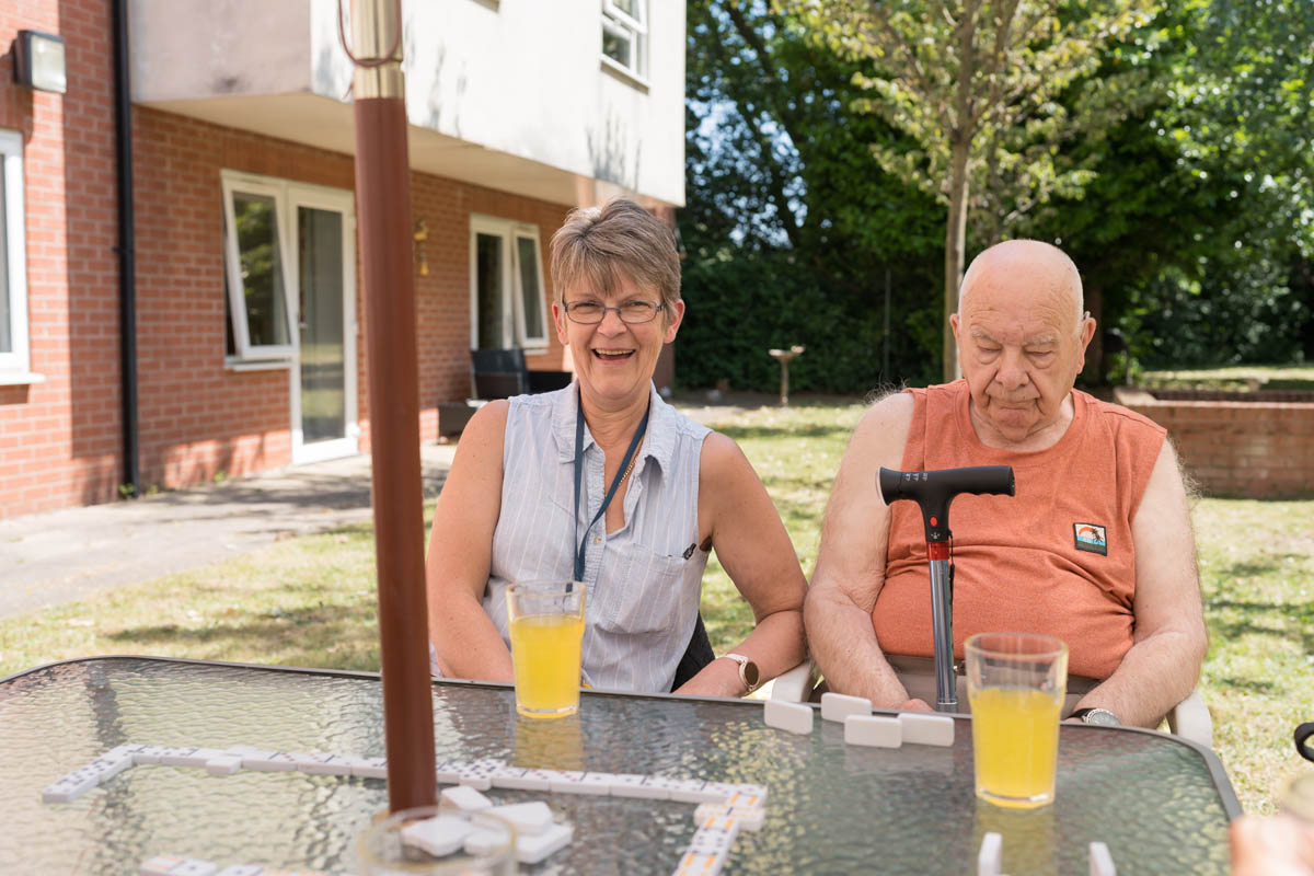 Two residents enjoying refreshments outdoors