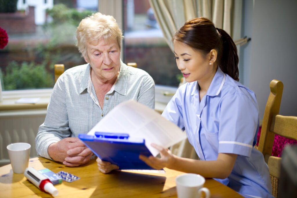Caregiver assisting an elderly resident with paperwork.