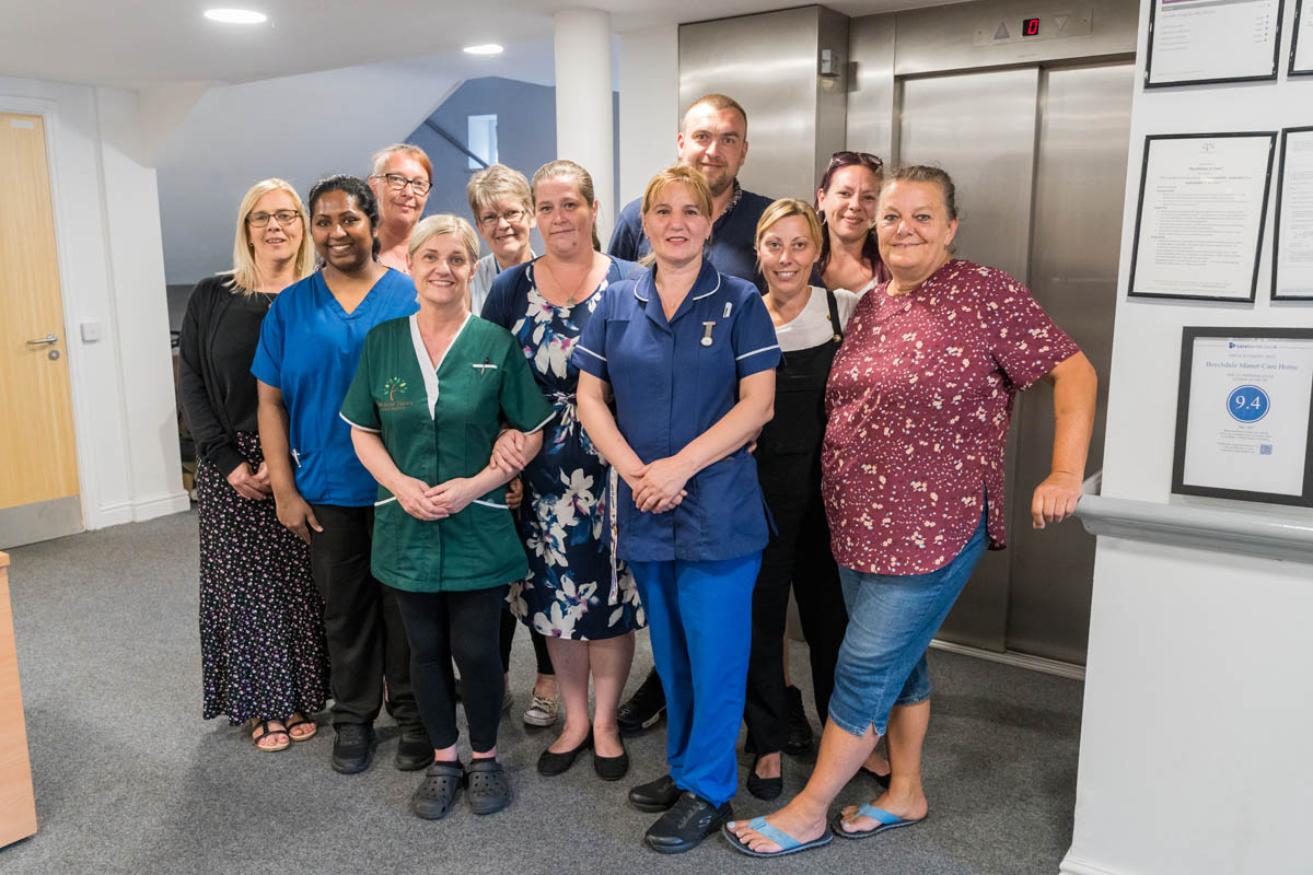 Staff members posing together in a common area.