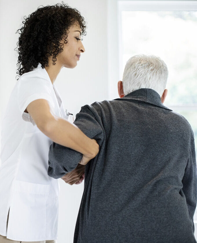 Caregiver assisting an elderly resident indoors