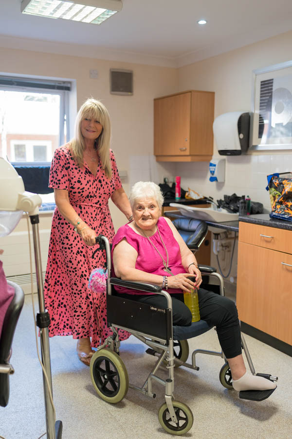 Care staff assisting a resident in a common area