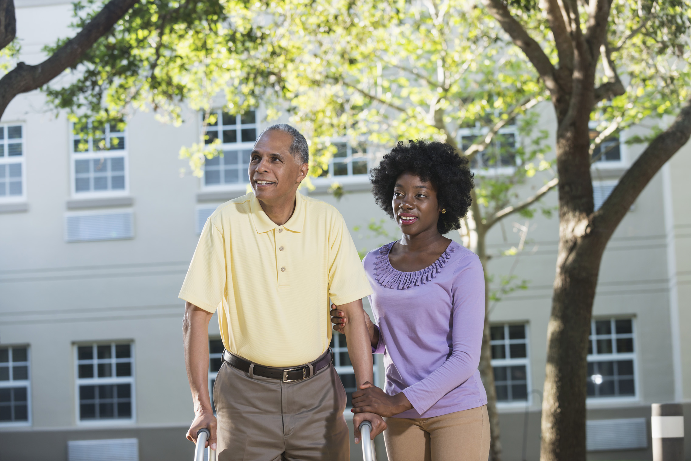 Senior man with caregiver in outdoor space
