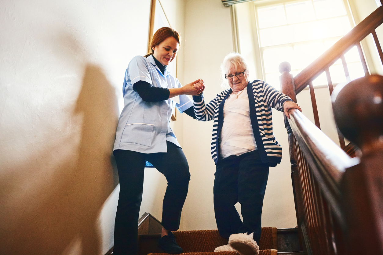 Staff assisting a resident down the stairs.