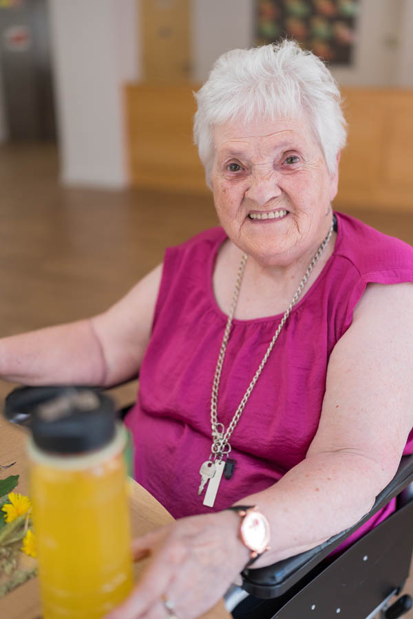 Senior woman smiling in a care home setting.