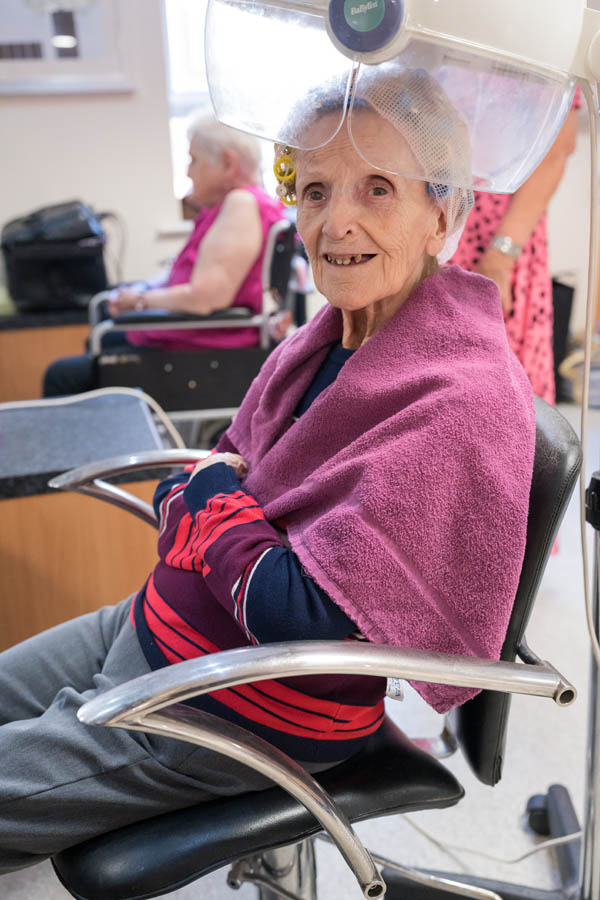 Resident enjoying a hair styling session