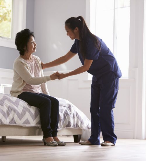 Caregiver assisting a senior resident in a room