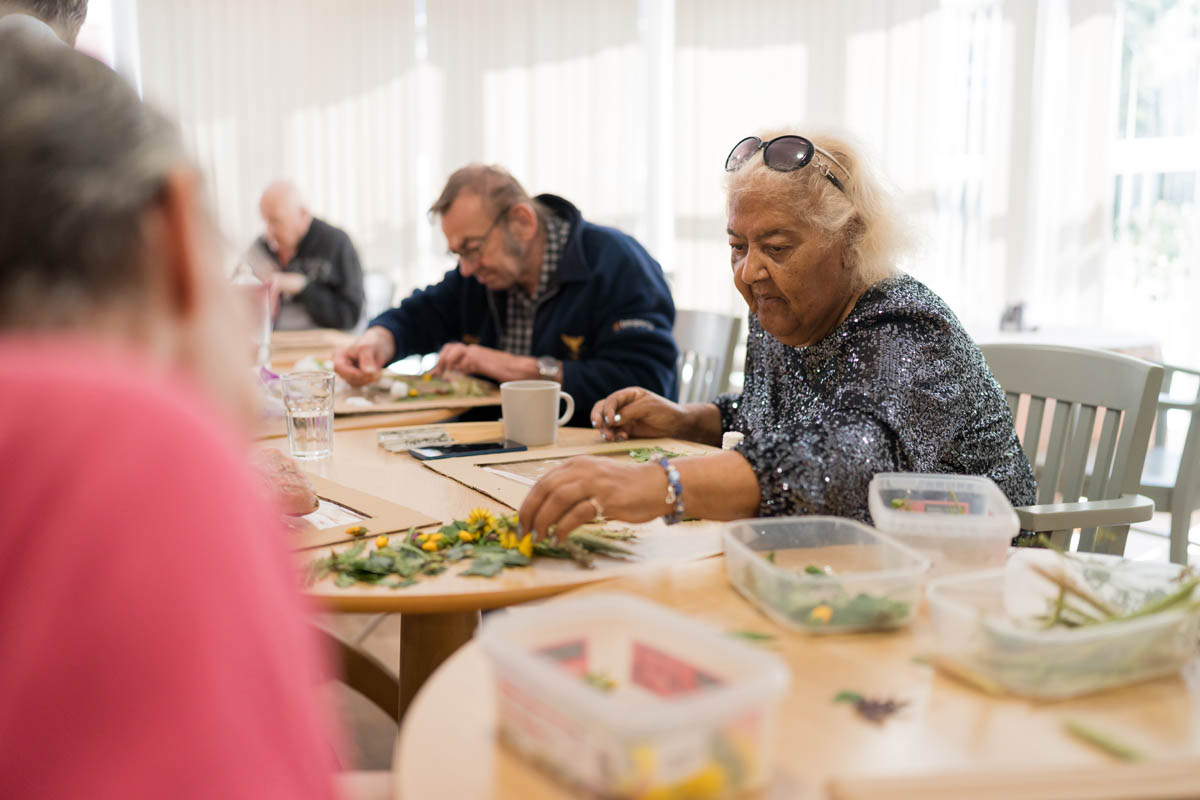 Seniors engaged in a crafting activity indoors.