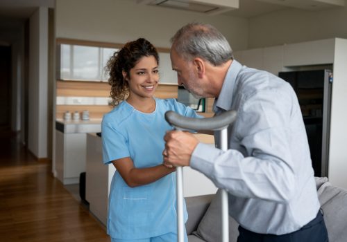 Healthcare professional assisting an elderly man