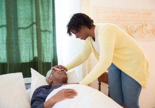 Caregiver assisting a resident in bed