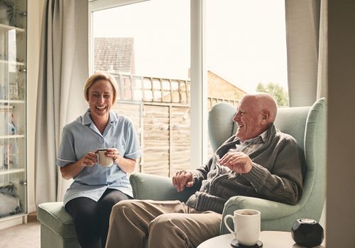 Caregiver and resident enjoying tea together.