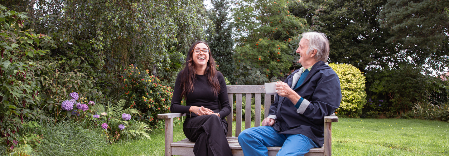 Residents enjoying conversation in a garden setting.