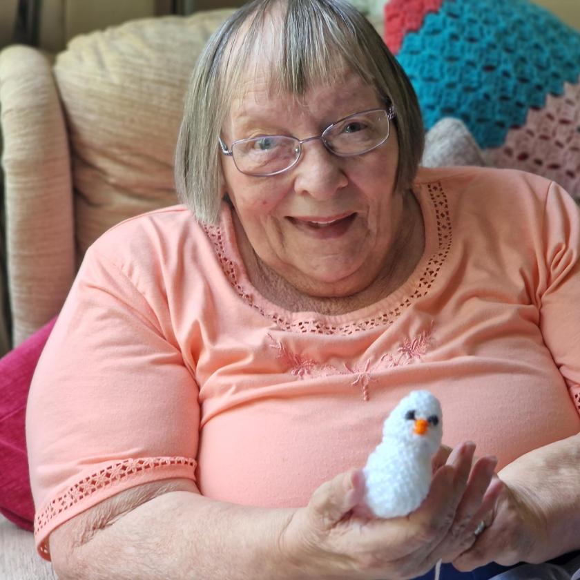 Senior woman holding a handmade stuffed animal.