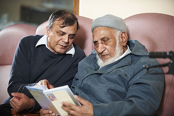 Two men discussing while reading together