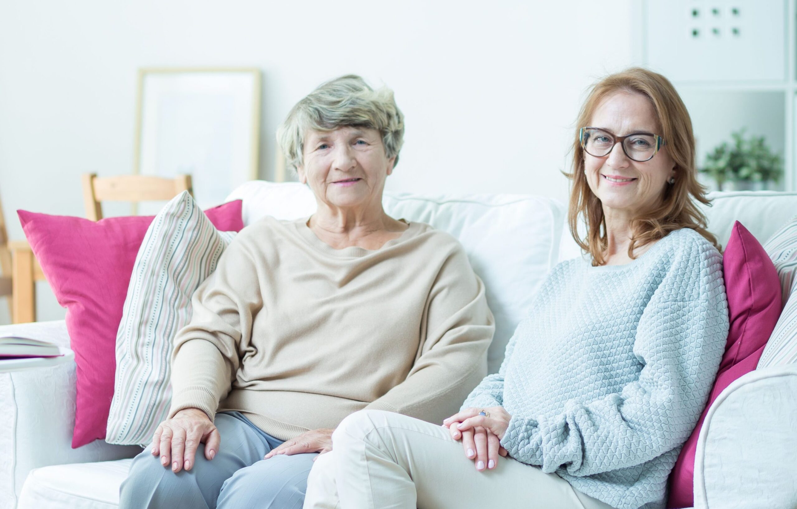 Two women sitting on a couch in a common area