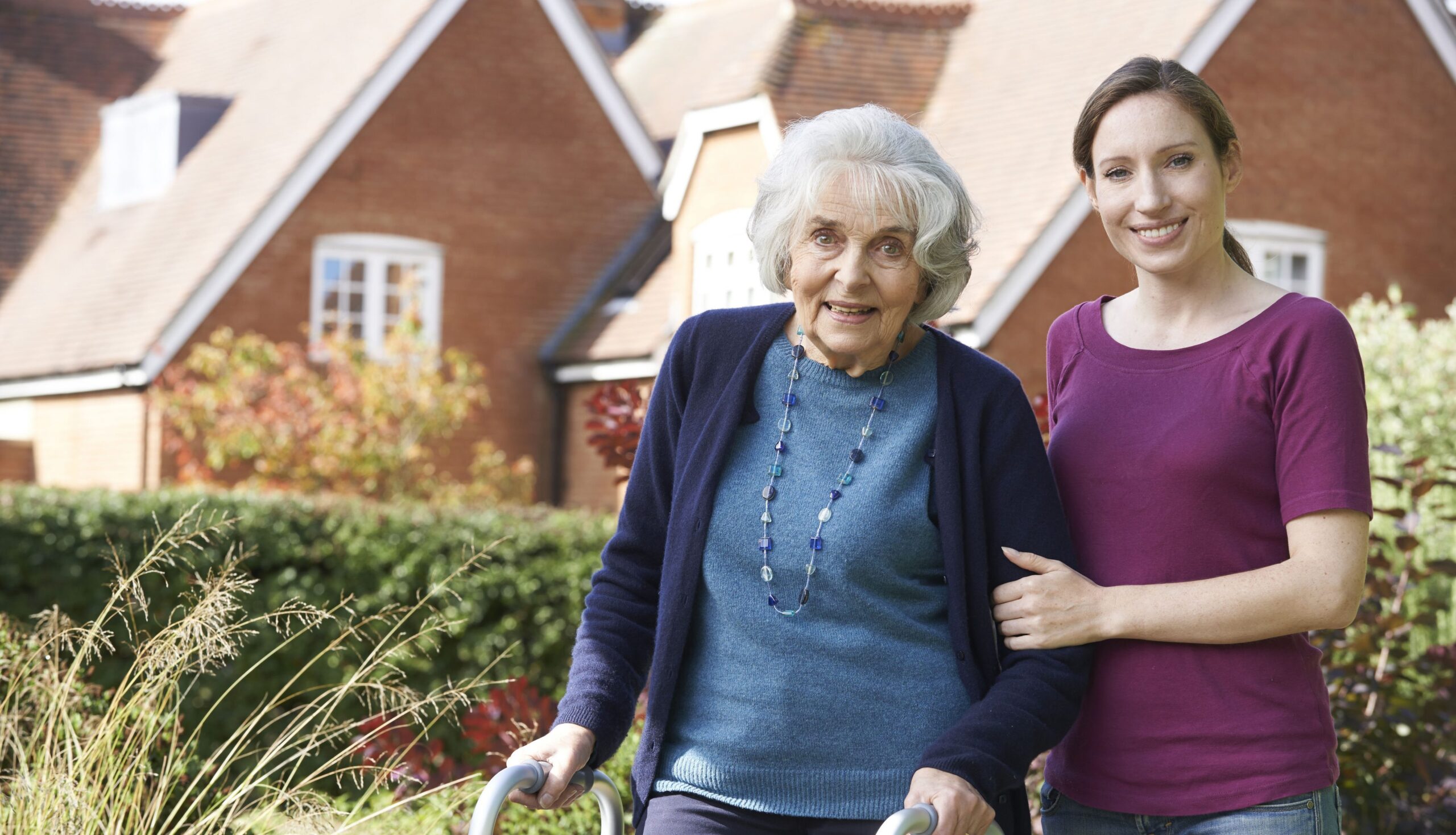 Elderly woman with caregiver in garden
