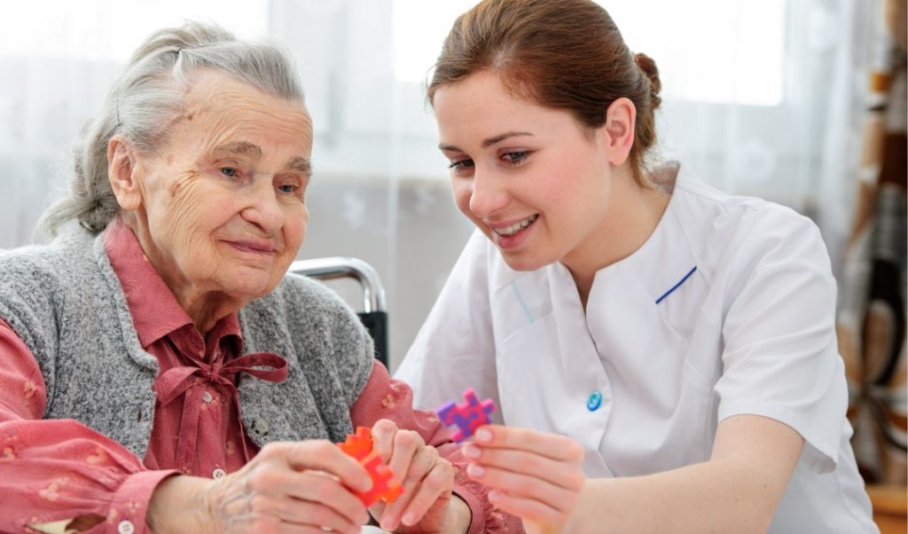 Caregiver and resident engaged in a puzzle activity.