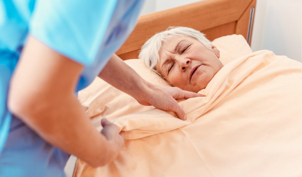 Nurse attending to a resident in bed
