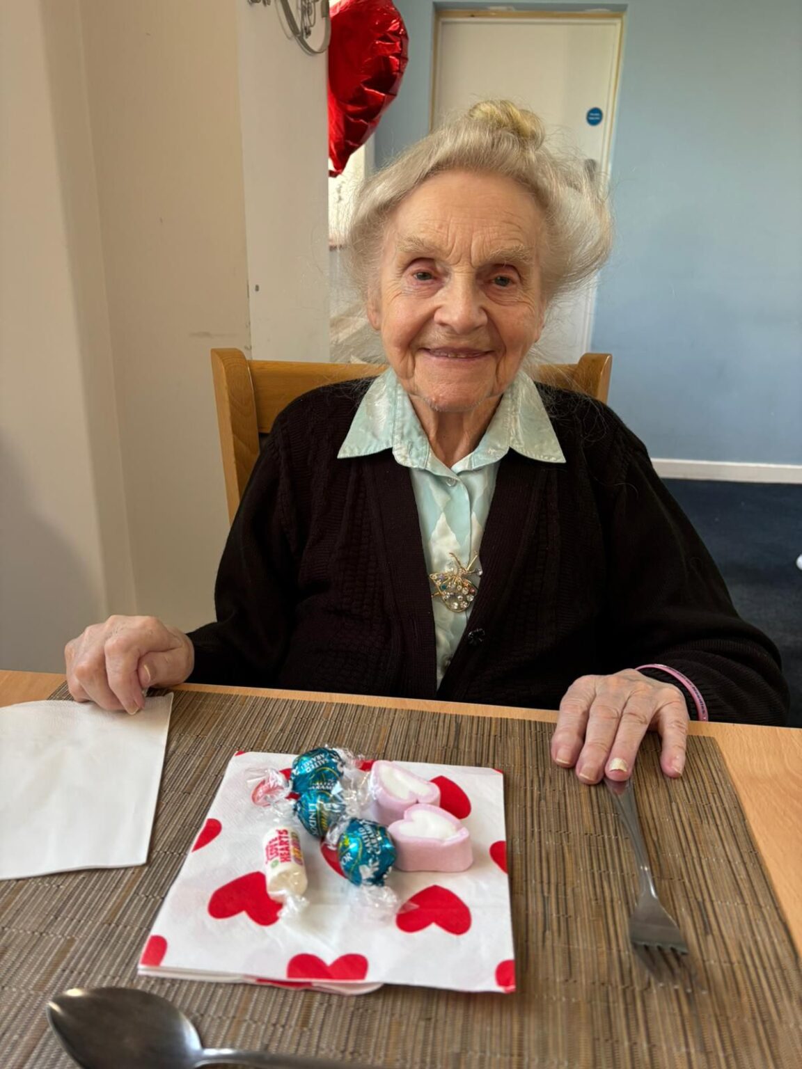Elderly woman at a dining table with candy.