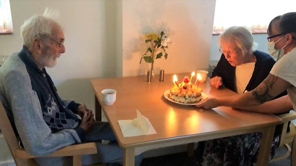 Residents celebrating a birthday with cake.