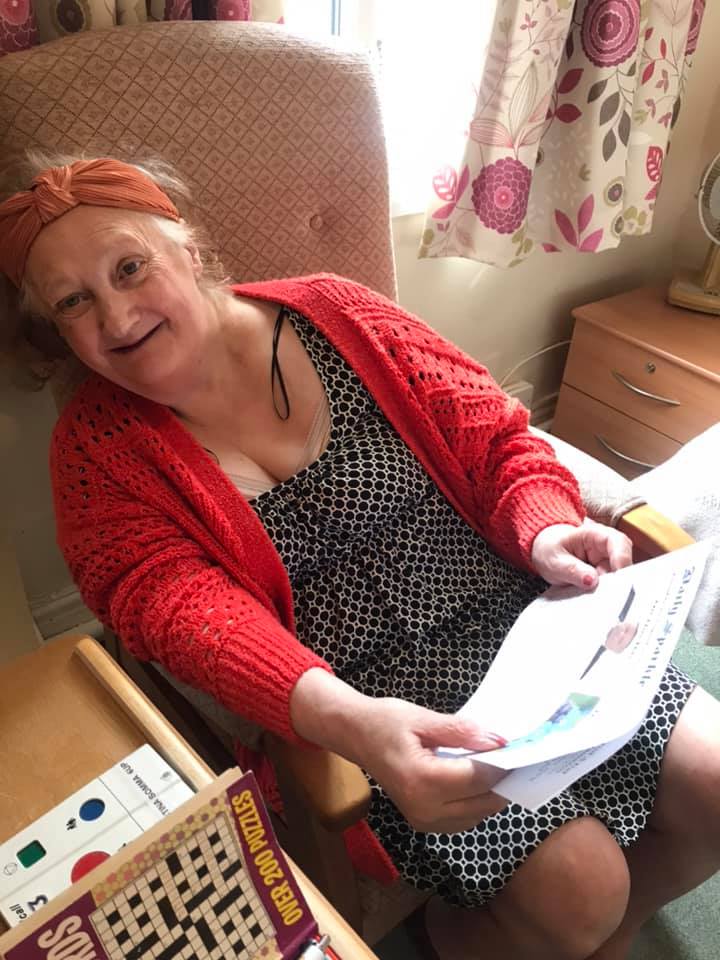 Resident enjoying an activity in a cozy chair