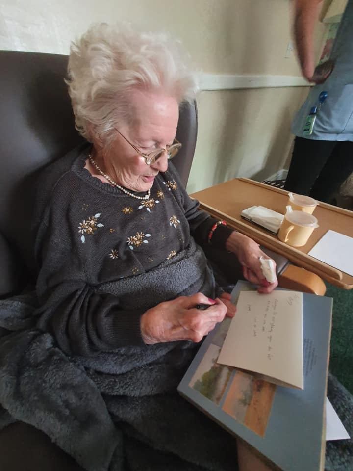 Resident writing a note in a cozy setting.