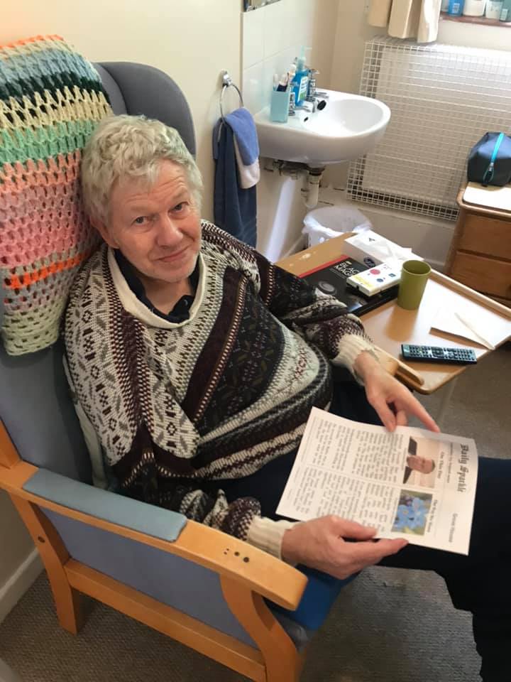 Senior man reading a newspaper in a cozy room.