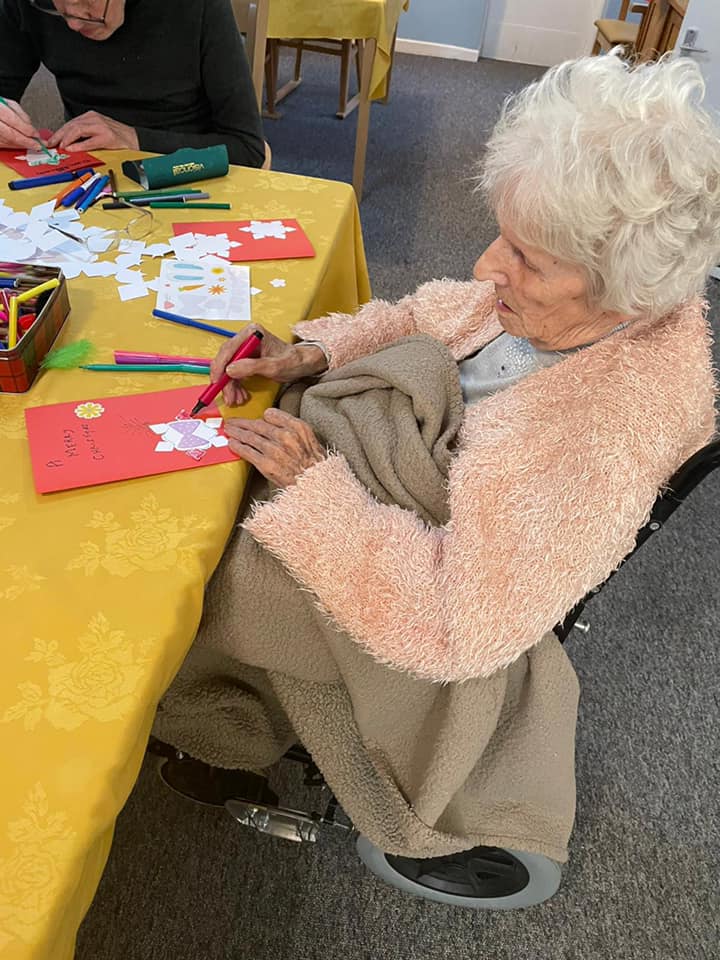 Elderly resident crafting on a table
