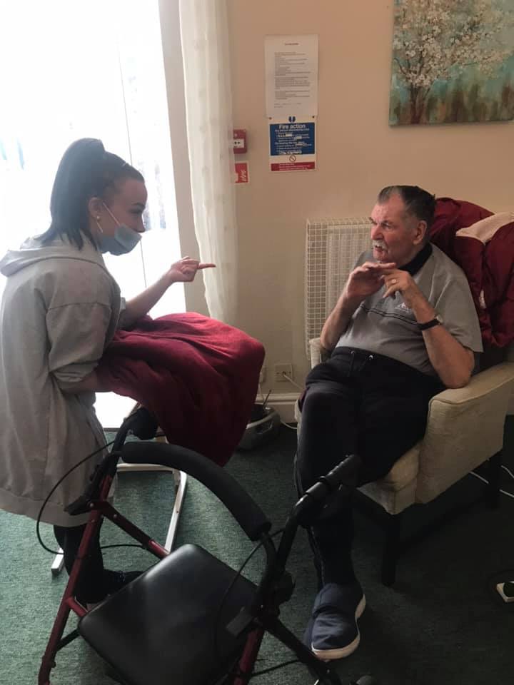 Staff member interacting with a resident in a common area.
