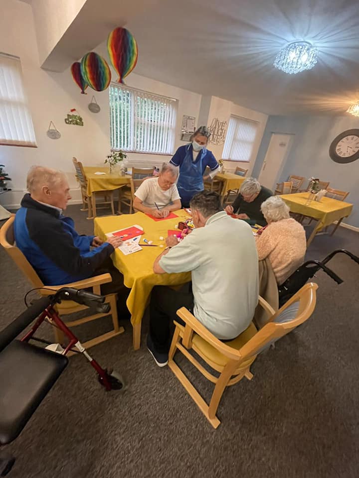 Residents engaged in an activity at a table.
