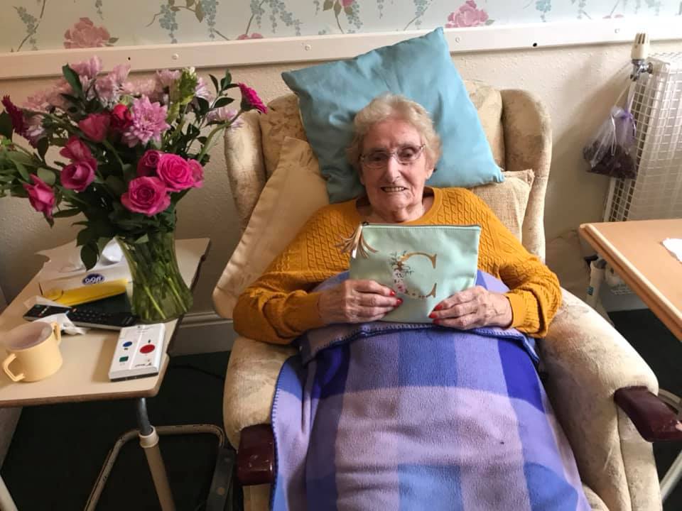 Elderly woman with flowers and a book in her lap