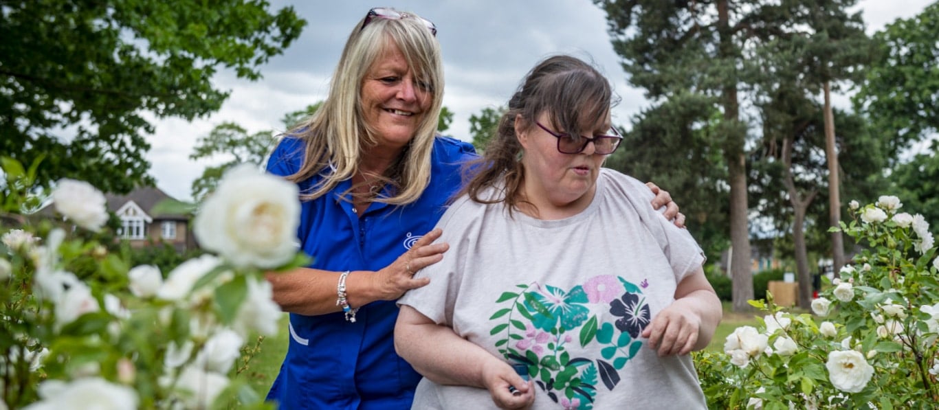 Staff member assisting resident in garden