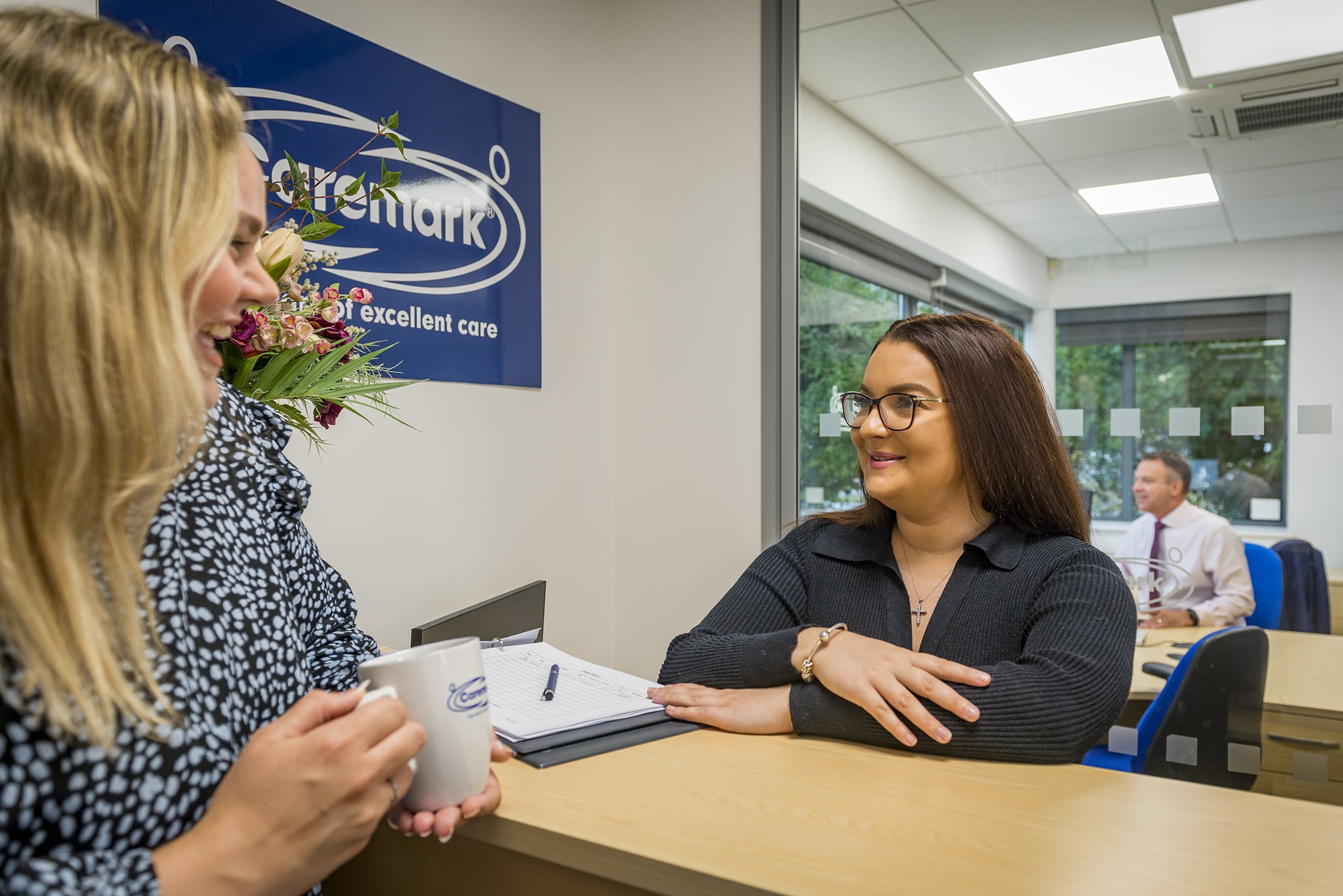 Two staff members interacting at reception
