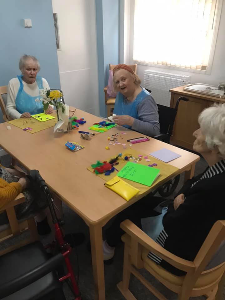 Residents engaging in a craft activity at a table.