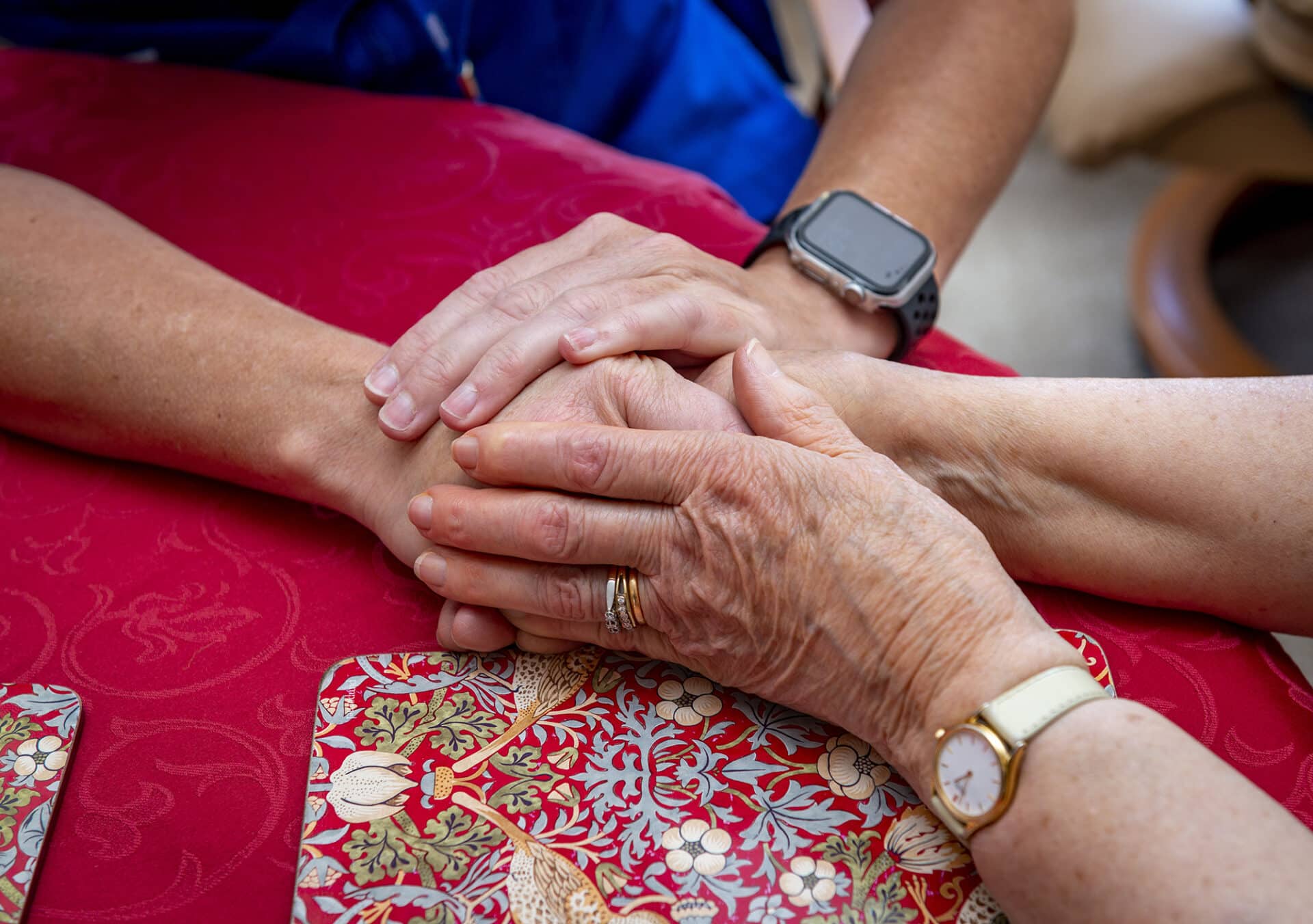 Two hands in a caring embrace on a table.