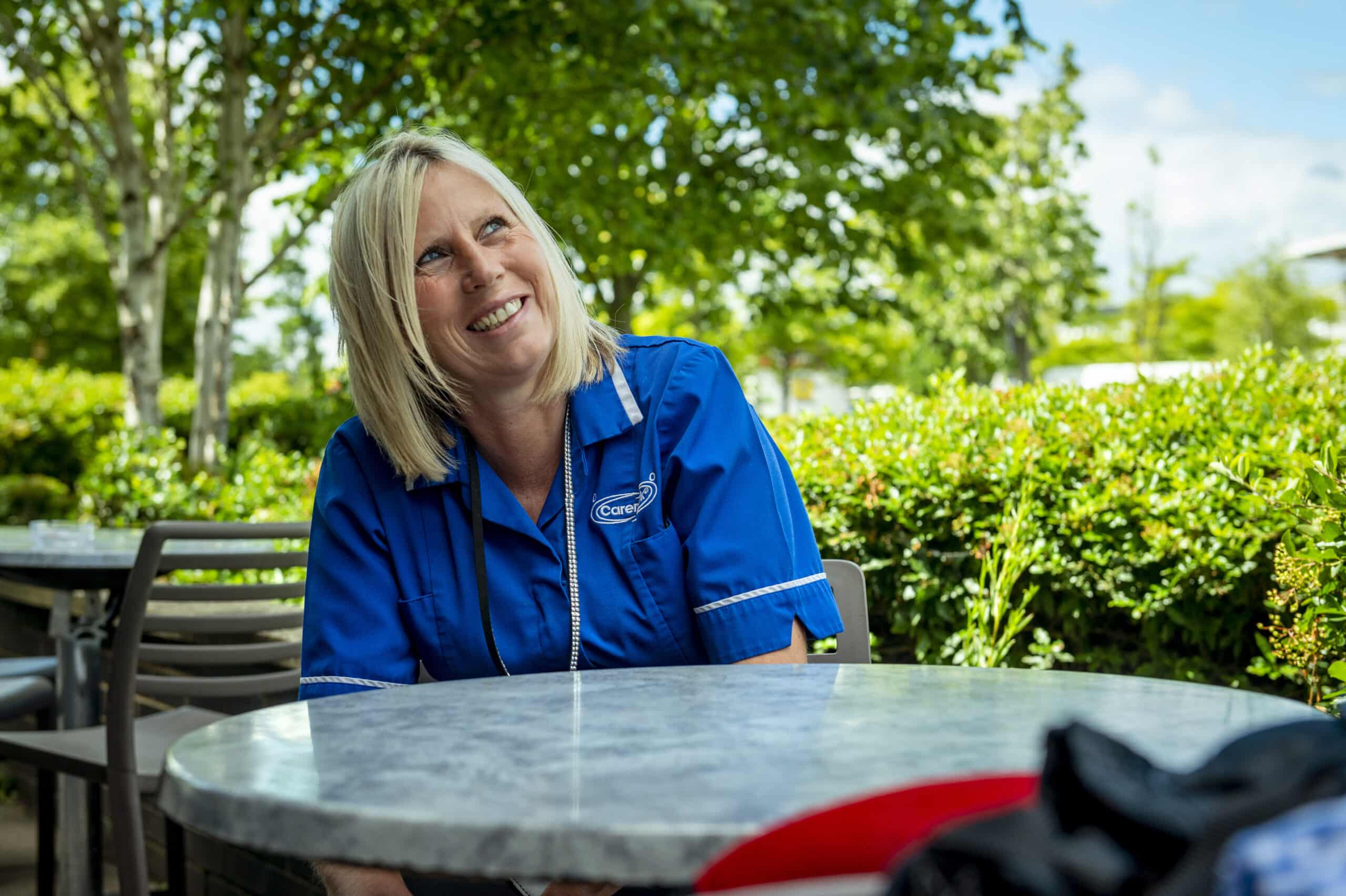 Staff member smiling outdoors in a garden area