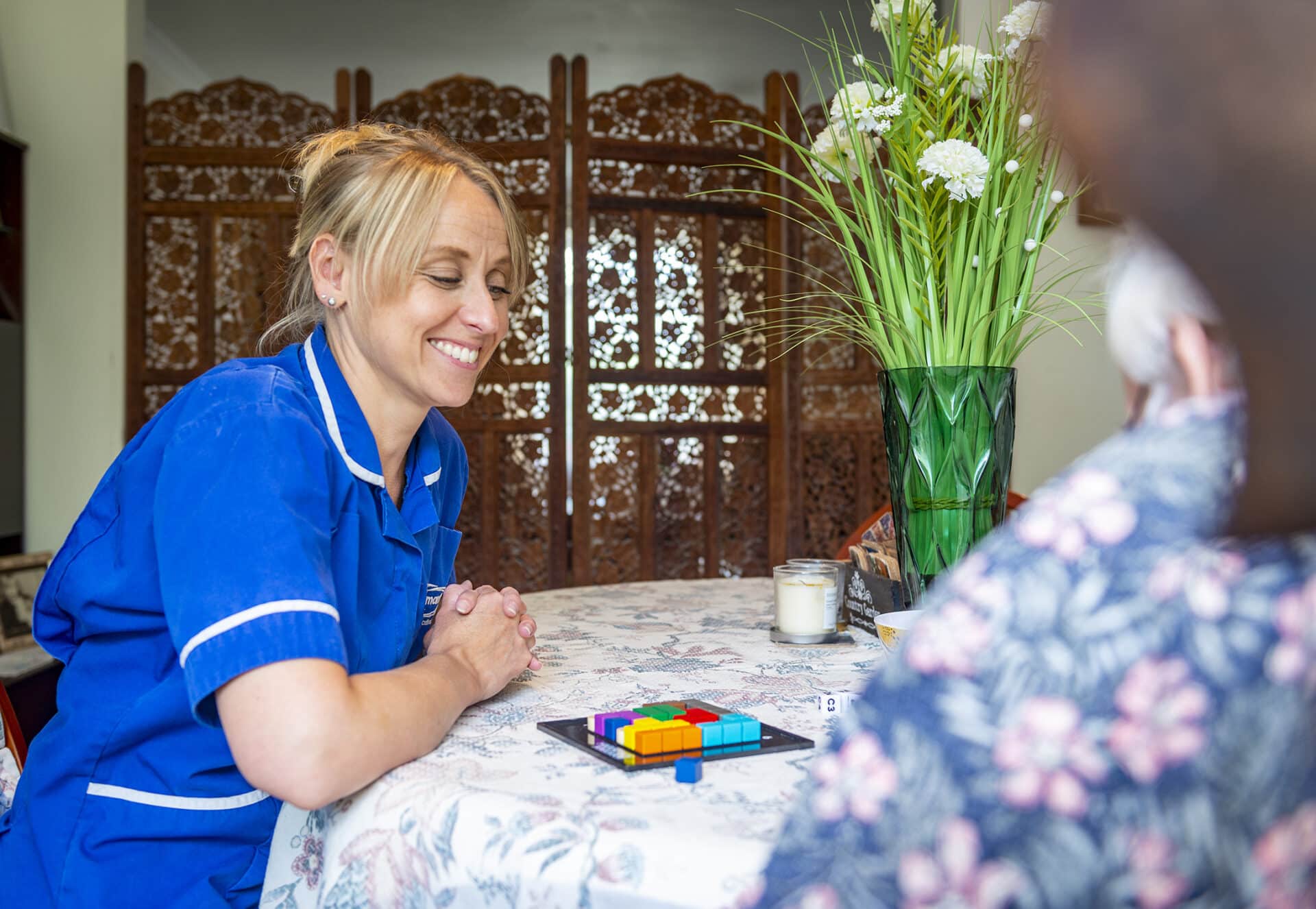 Staff interacting with a resident at a table.