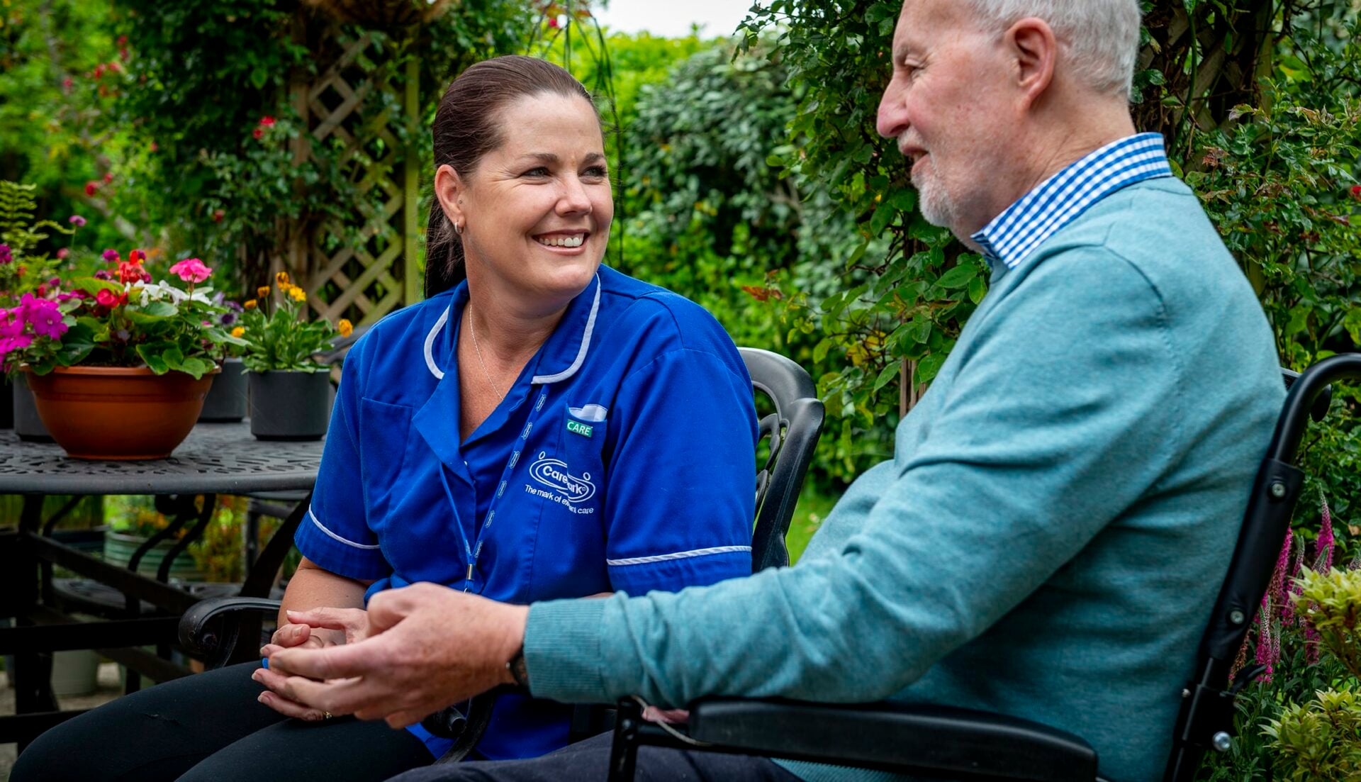 Care staff engaging with a resident in a garden
