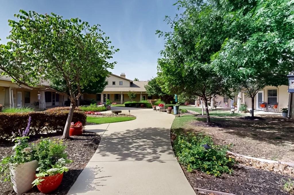Pathway surrounded by greenery and buildings