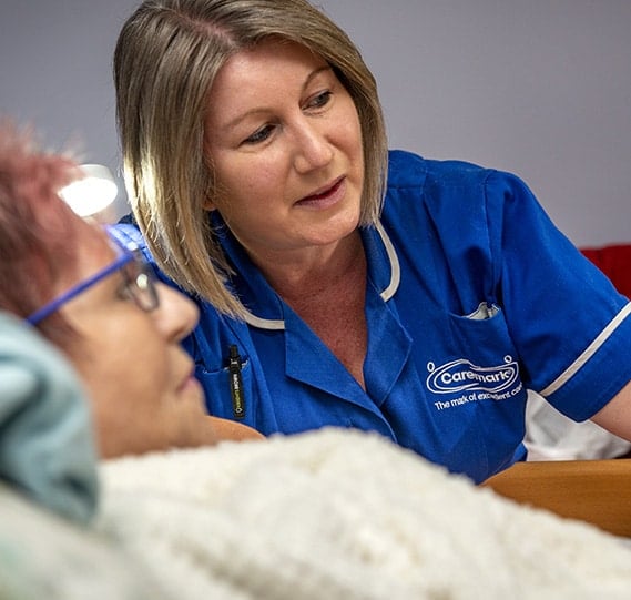 Nurse attending to a resident in a care setting.