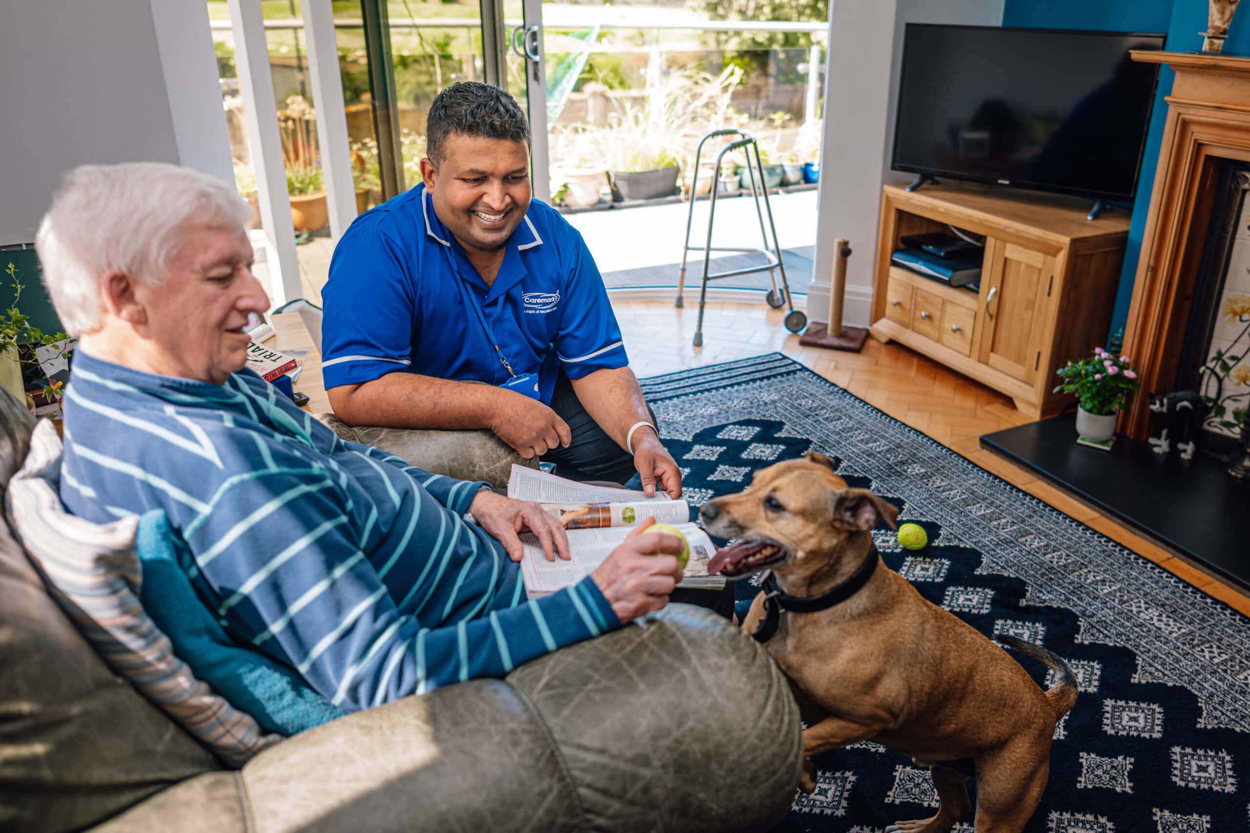 Caregiver engaging with resident and dog indoors