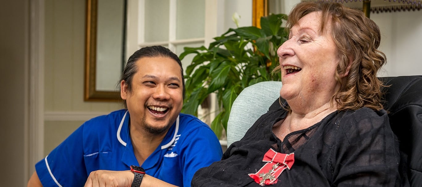 Staff interacting joyfully with resident.