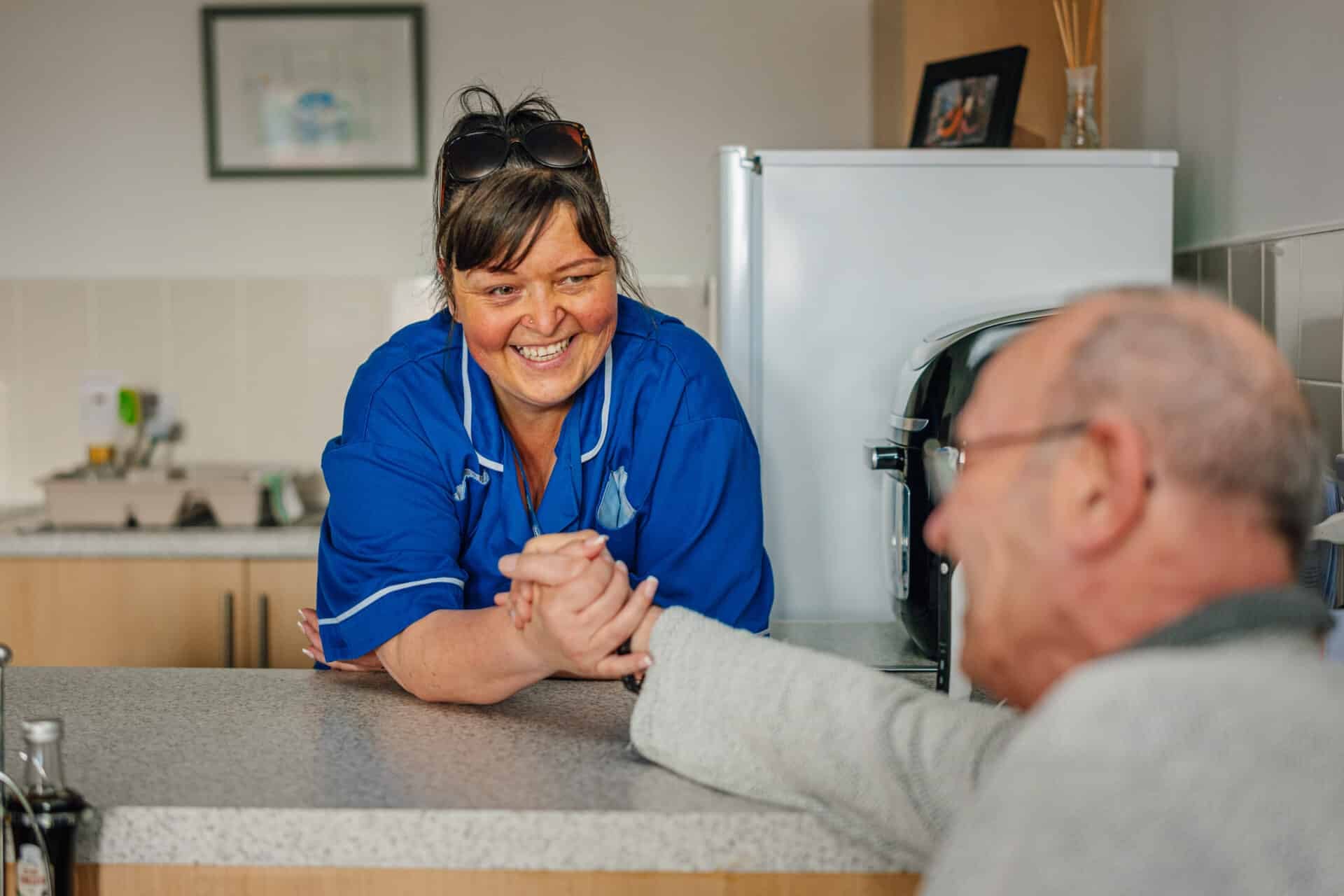 Staff member engaging with a resident in the kitchen.