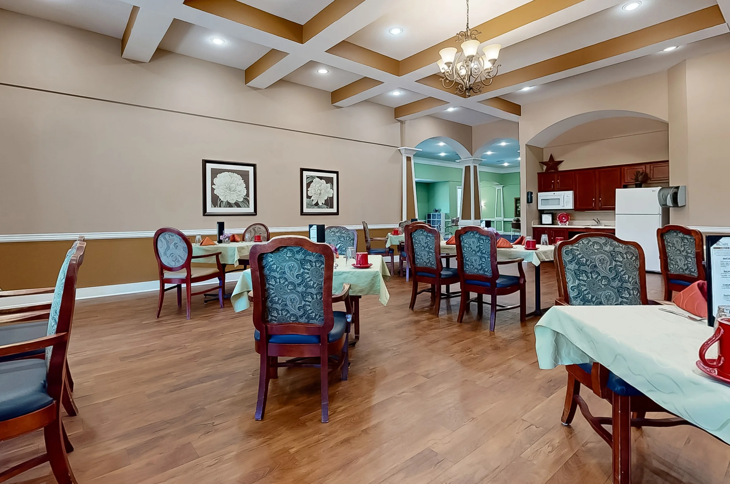 Dining room with tables and chairs set for meals.