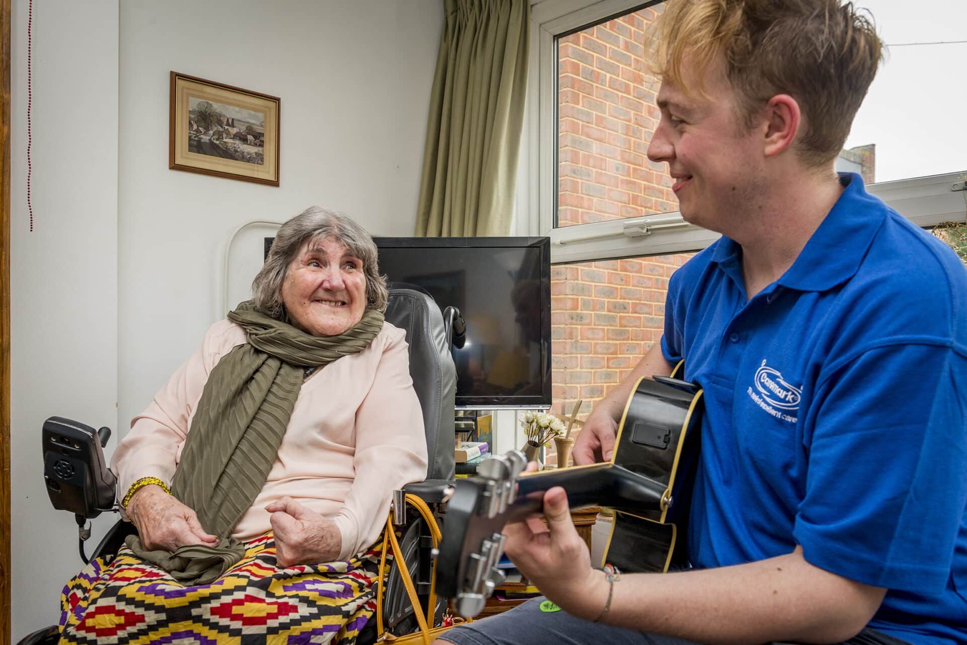 A resident enjoying music with a caregiver.