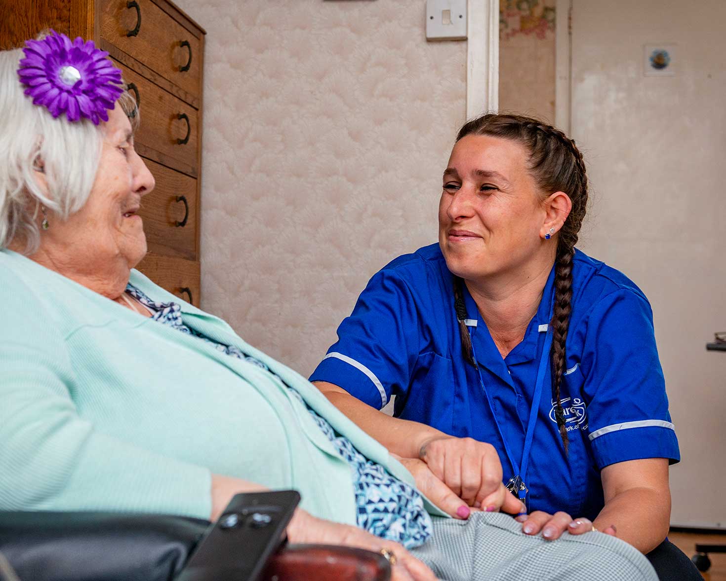 Caregiver interacting with a resident in a warm setting.