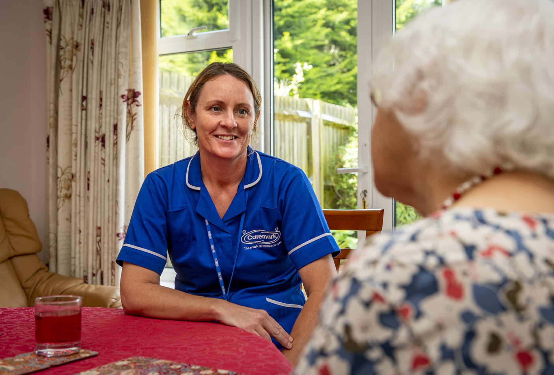 Staff member engaging with a resident in a cozy setting.