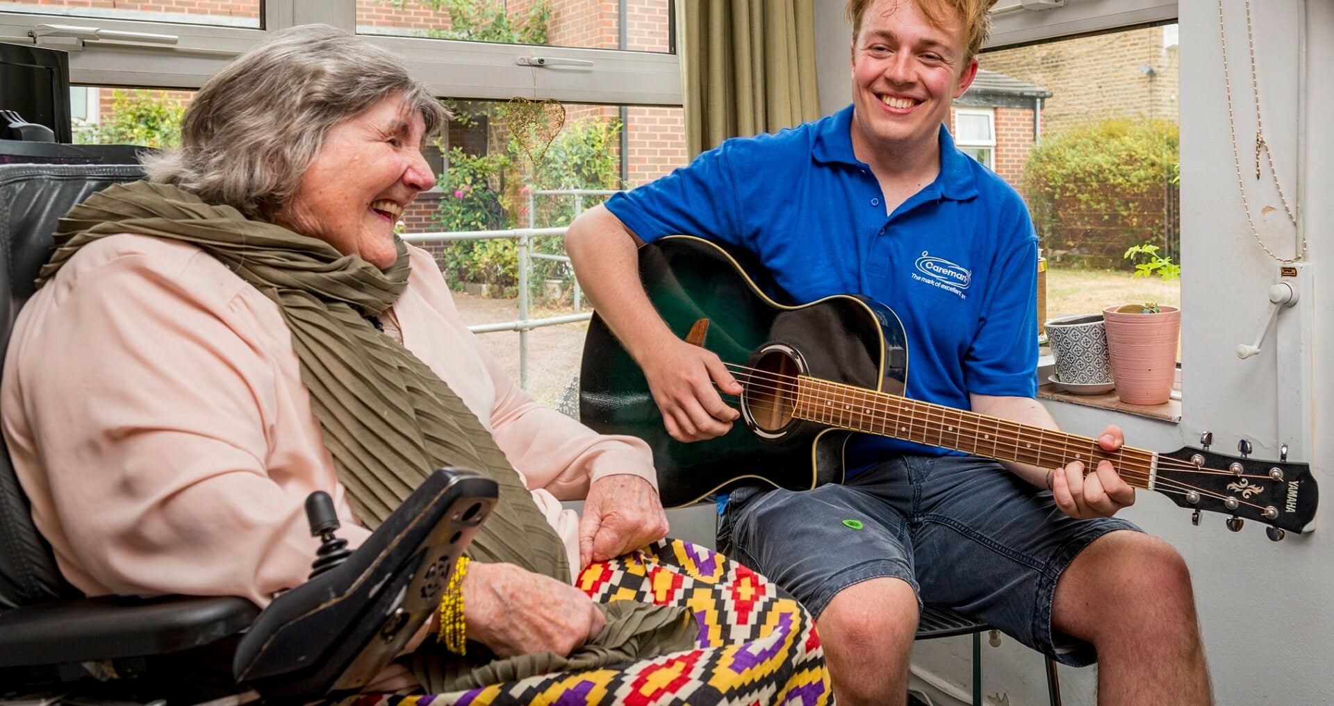 Resident enjoying music therapy with staff member.
