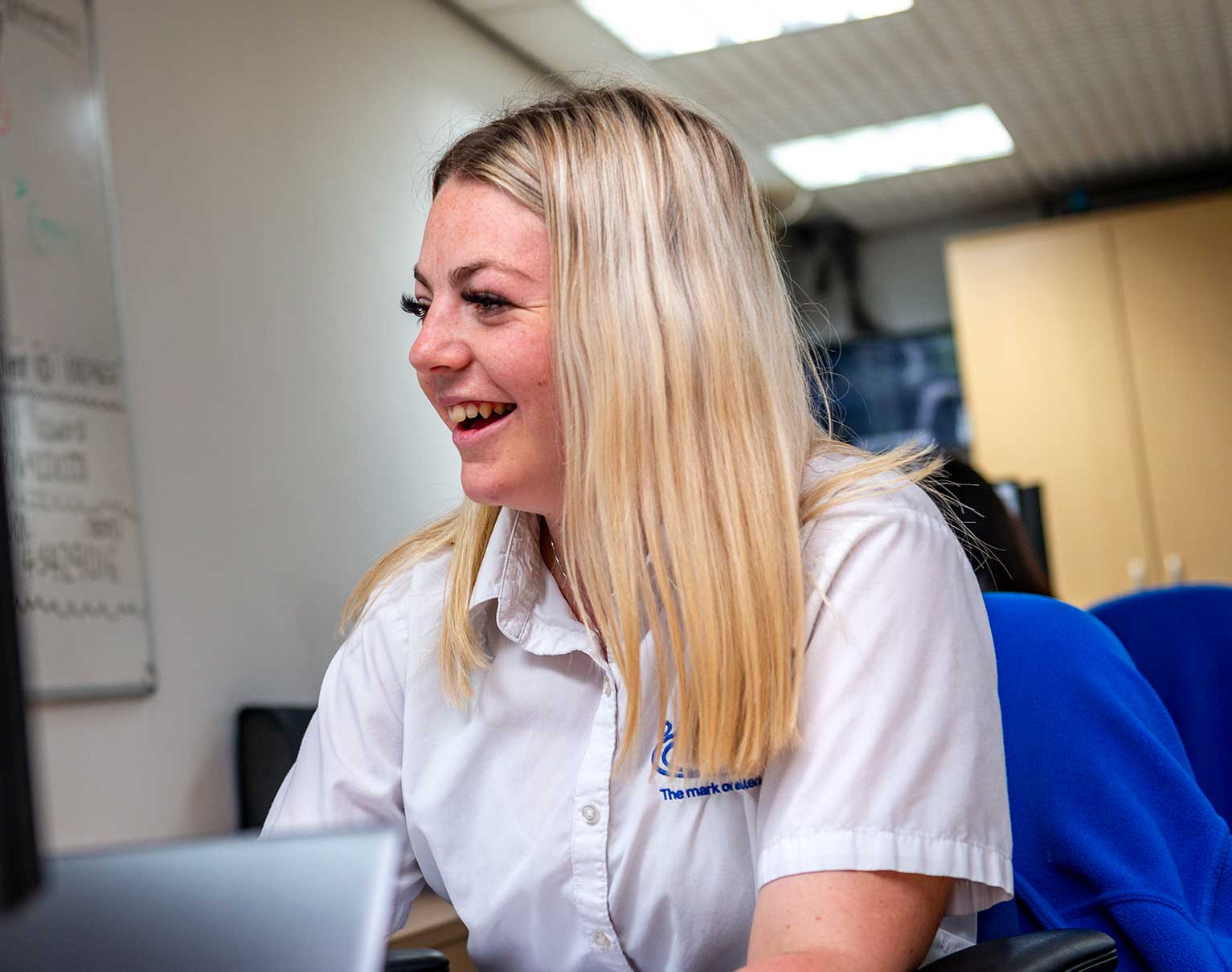 Staff member smiling while working at a desk