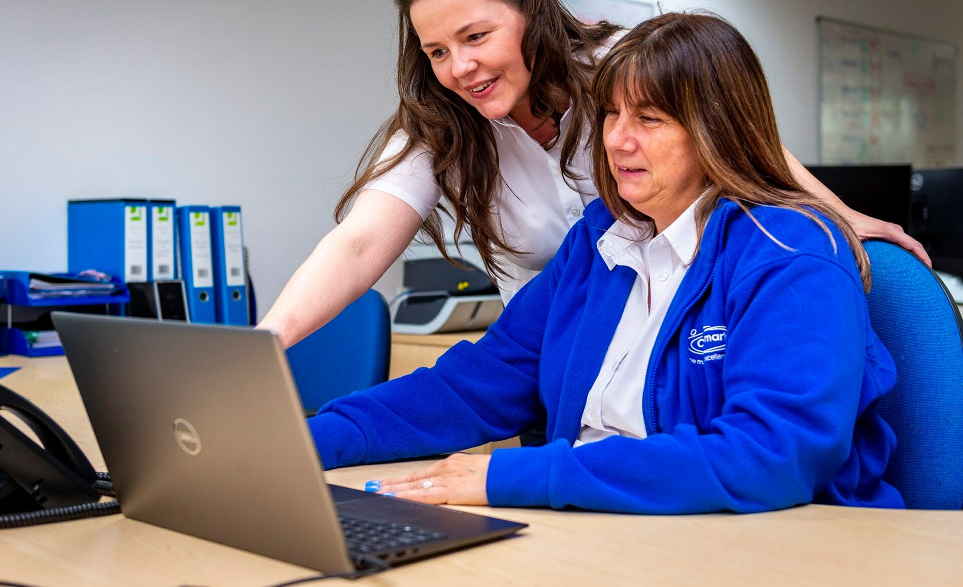 Two staff members collaborating at a desk